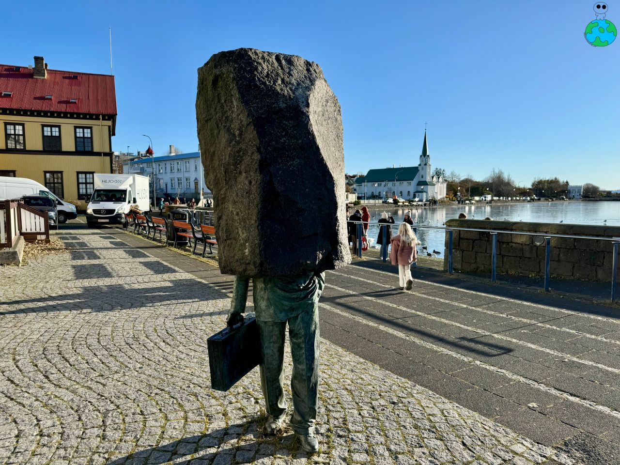 【冰島景點】托寧湖Tjörnin 上百隻天鵝齊聚一堂,最美麵包湯 - 第6張圖 托寧湖旁的石頭上班族裝置藝術